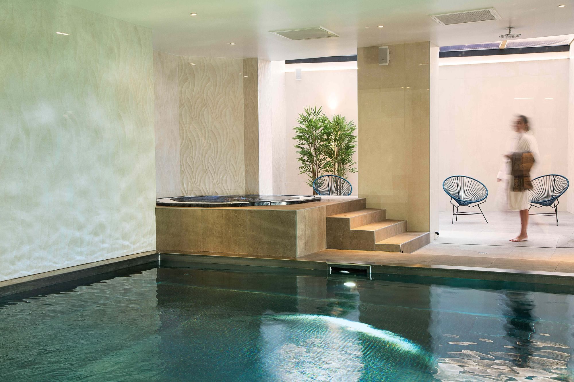 Espace piscine intérieure avec chaises longues à Oceania Hotels